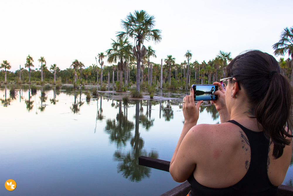 Amanda registrando o pôr do sol na Lagoa das Araras